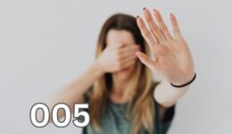 A woman with long brown hair covers her face with her hands, conveying a sense of overwhelm and introspection.