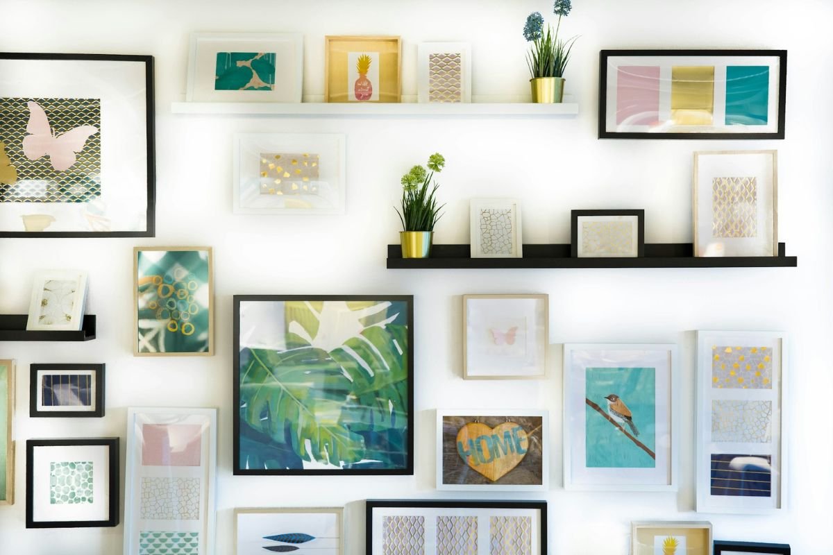Various picture frames and decorative items on a white wall.
