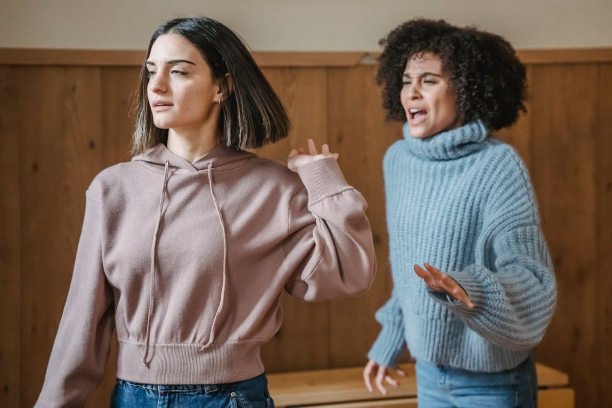 Conflict Unmasked: When Tensions Erupt women, engaged in an intense confrontation in a room.