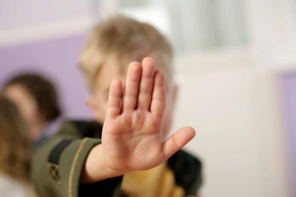 Setting Boundaries: The Power of 'No' A young boy’s hand held up in a stop gesture, symbolizing the act of setting boundaries and saying "no."
