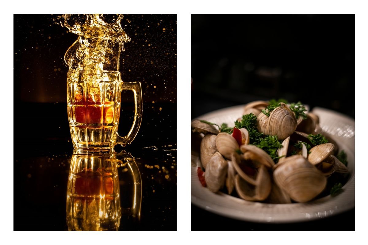 Beer Splash and Seafood Platter A glass of beer splashing next to a plate of clams garnished with herbs.