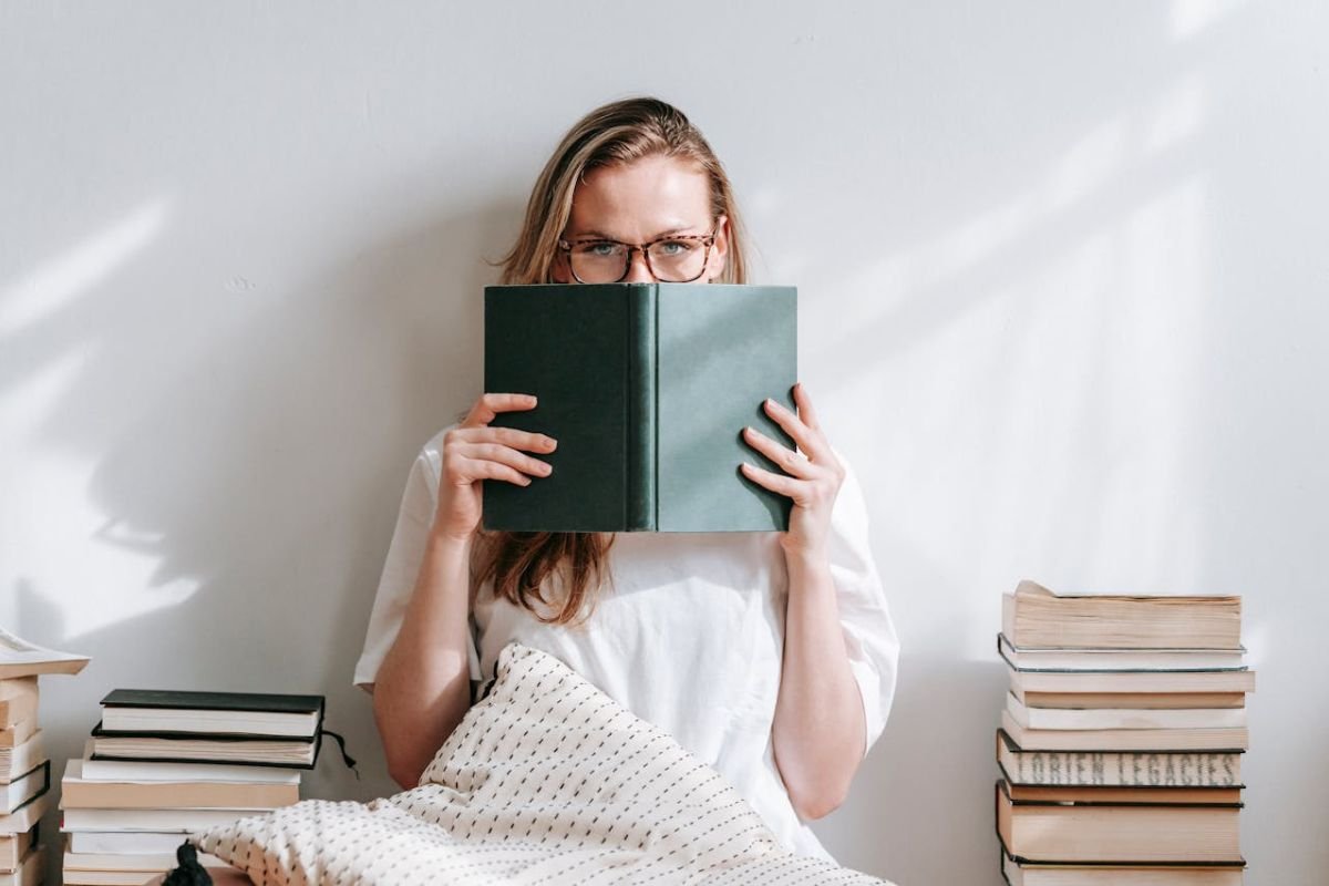 The Art of Saying No: What Smart People Do Differently Young woman sitting near tall stacks of books, looking annoyed because she has been disturbed.