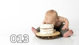 Close-up of a child sitting beside a round cake, questioning if the treat is truly what it seems.