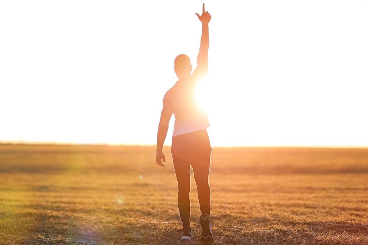 Silhouette of a man pointing upwards, symbolising encouragement and motivation.