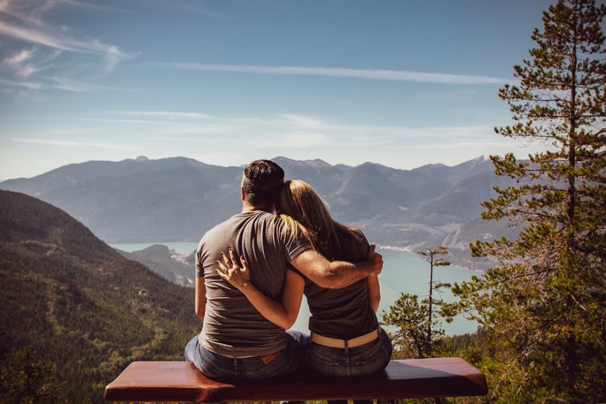 Finding Fulfilment Together: A Moment of Connection A couple sits close together on a bench, representing mutual understanding and the fulfilment of core needs in marriage.