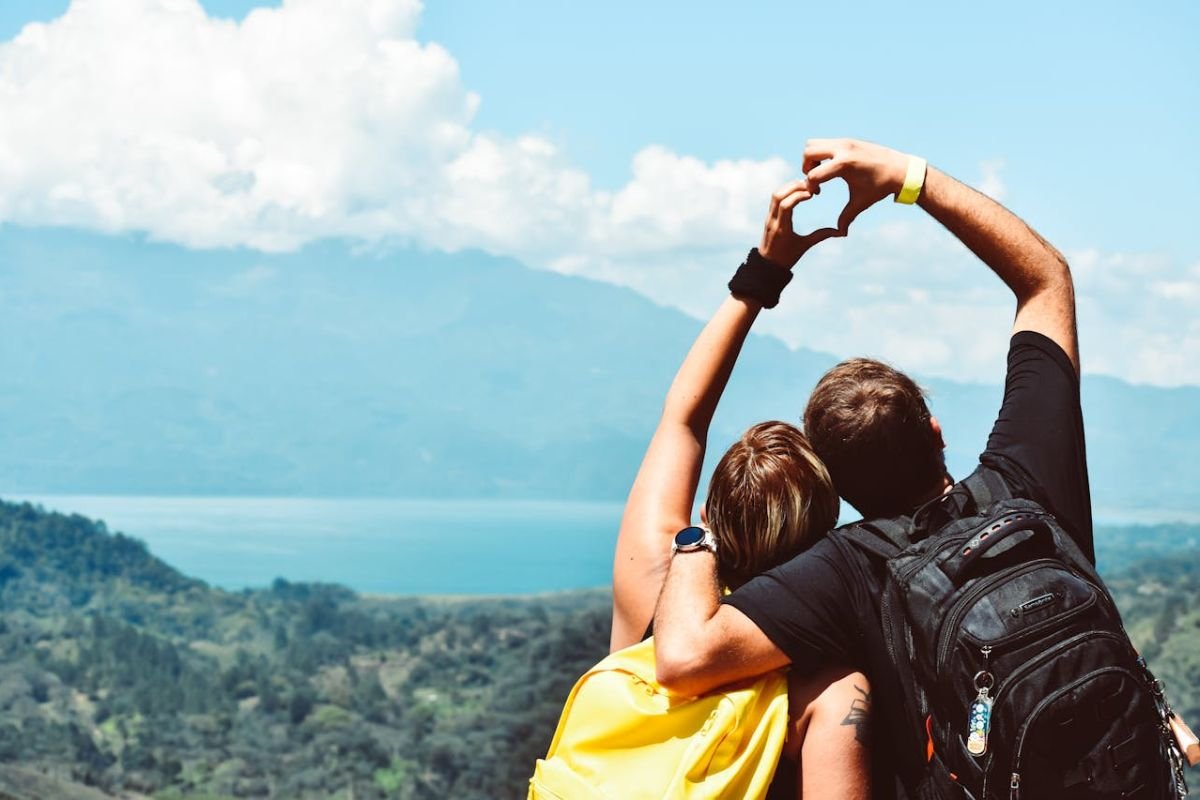 Couples Reconnecting Through Shared Adventures A couple forming a heart shape with their hands while enjoying outdoor adventures, symbolising shared experiences and rekindled connection.