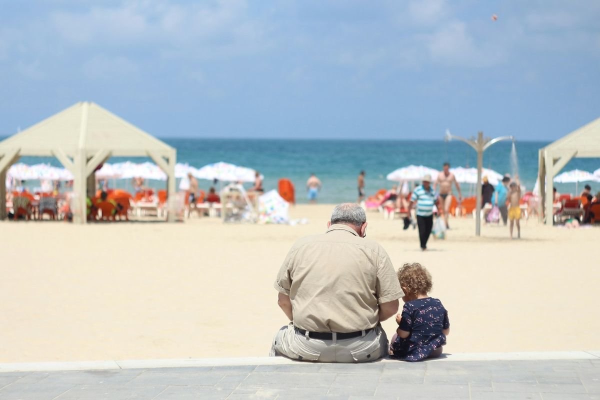 Balanced Grandparenting: Supporting Without Overstepping Boundaries in Childcare A grandfather sitting with his granddaughter on a bench outdoors, representing supportive but balanced grandparental involvement in childcare.