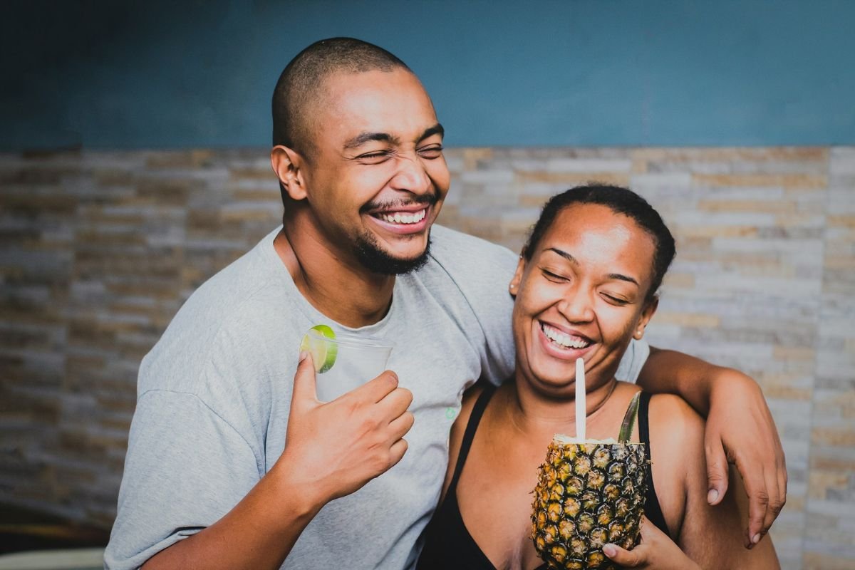 Adult siblings sharing a laugh together, standing side by side.