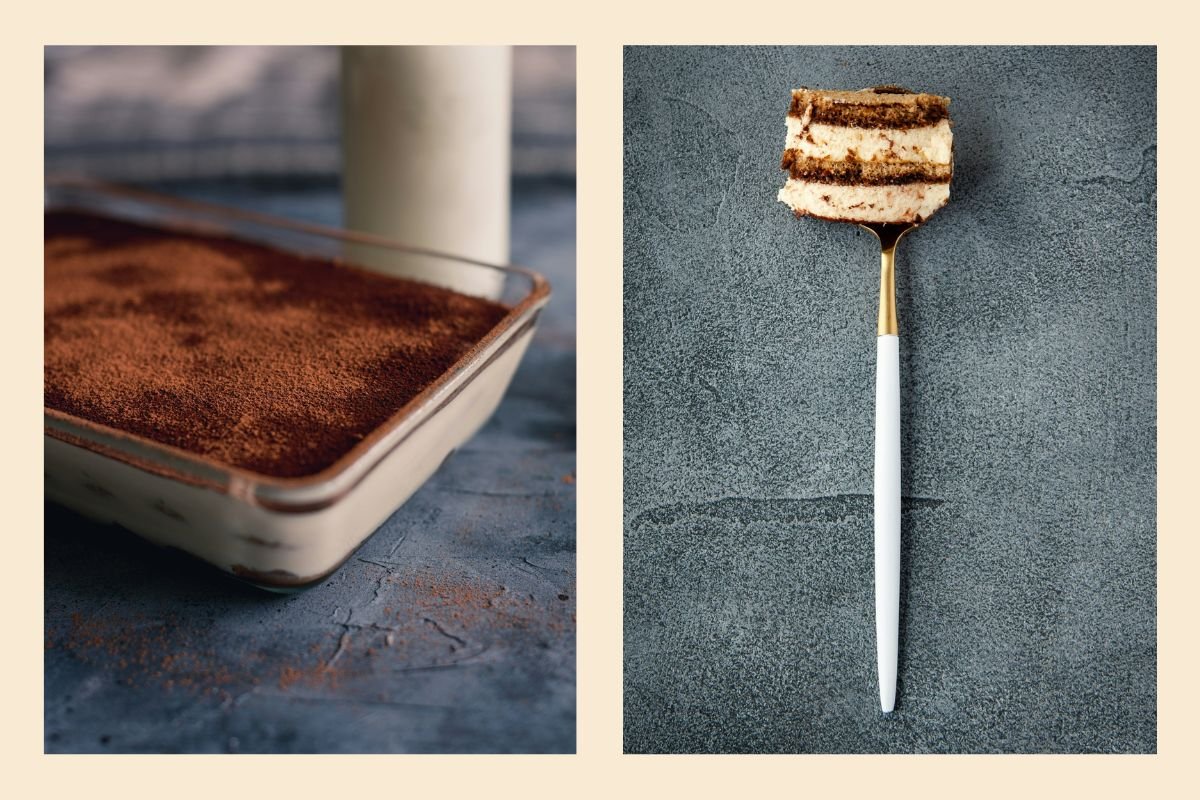 A close-up view of a fork holding a slice of tiramisu, placed against a grey, textured background. On the left side, a full dish of tiramisu dusted with cocoa powder sits on a dark surface.