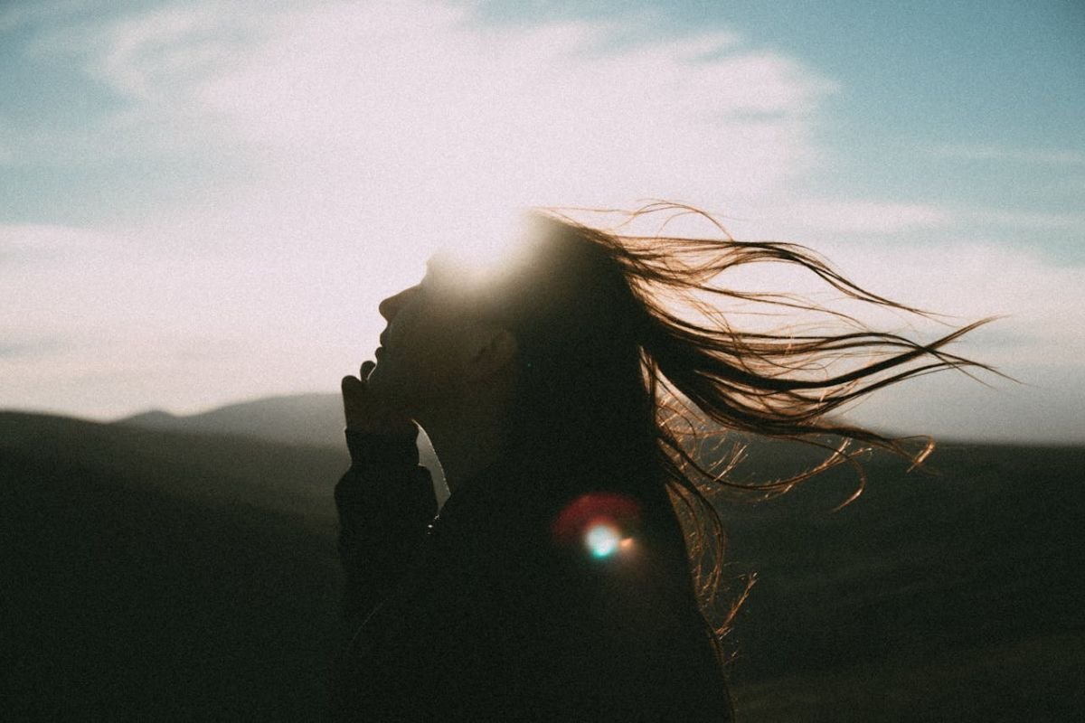 Self-Awareness: The First Step on the Journey to Growth A woman with long hair stands outdoors, symbolising self-awareness and inner reflection as essential steps toward personal growth.