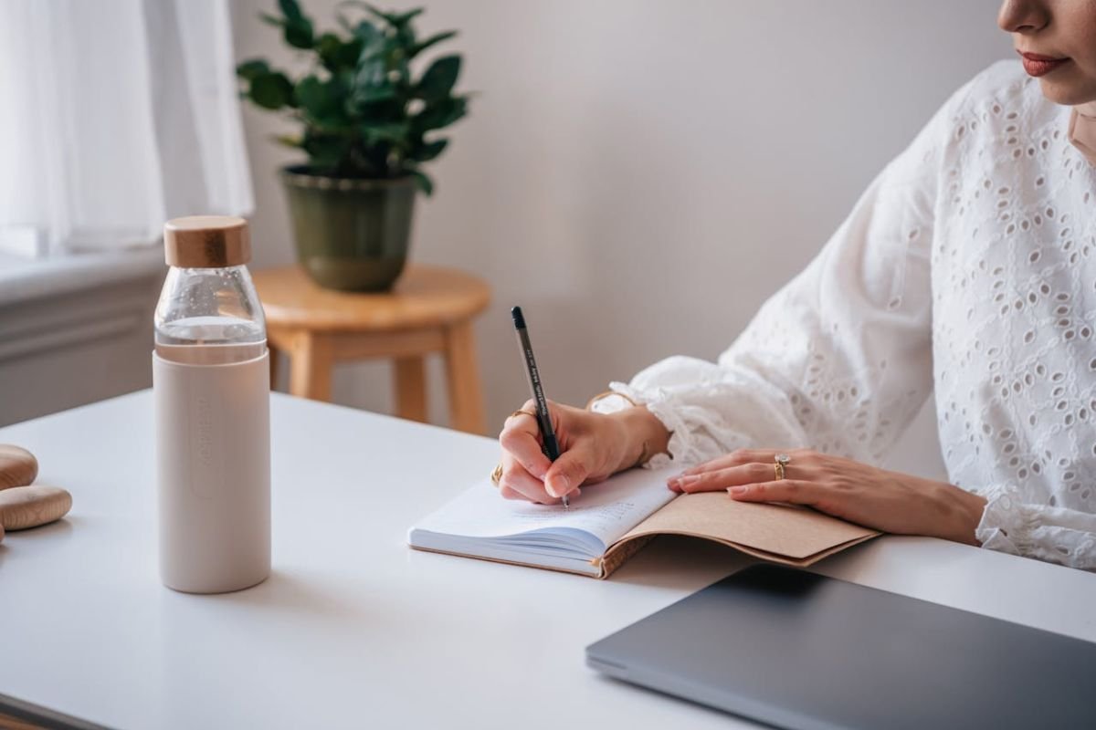 Journaling Emotions: Bringing the Subconscious to Light A person writing in a notebook, symbolising the importance of expressing emotions to bring subconscious thoughts into awareness.