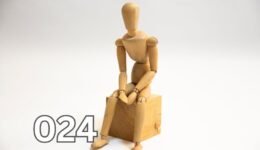 A wooden figurine sitting on a block, symbolising manipulation and control in human behaviour.