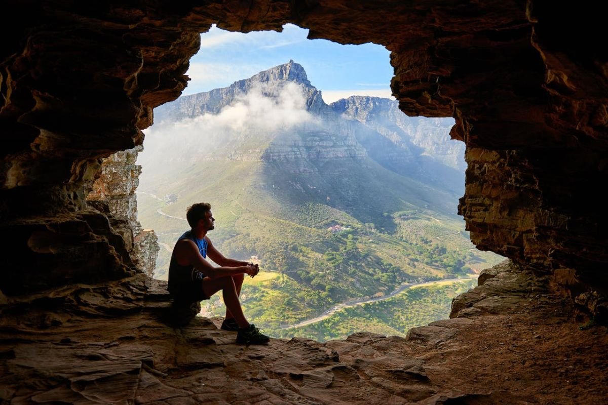 A man sitting alone in a cave, reflecting the introspection and clarity gained through solitude.