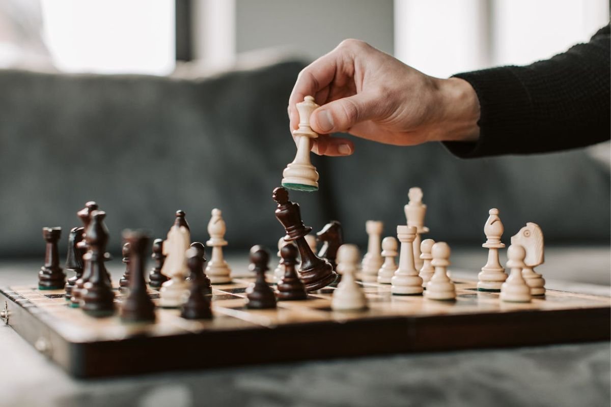 Chess Game as a Symbol of Strategic Manipulation A close-up of a person playing chess, symbolising strategic manipulation and decision-making in psychology.