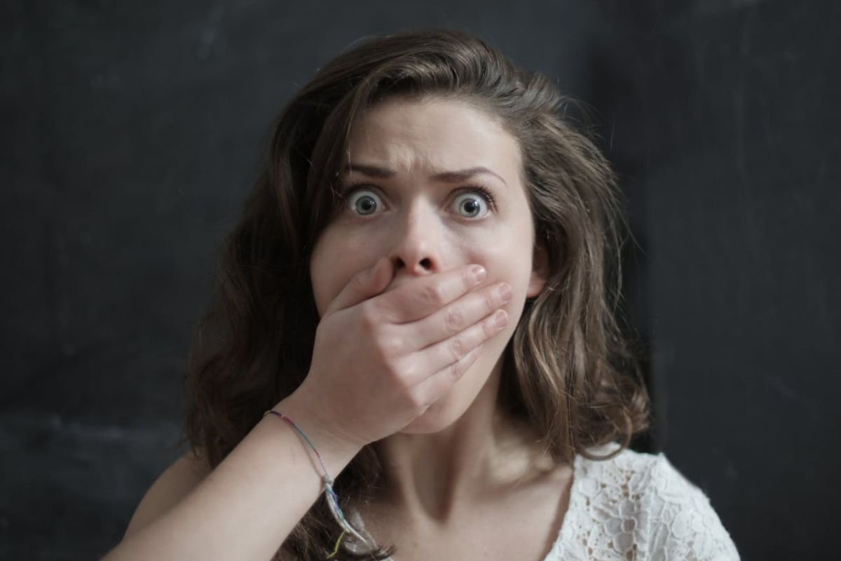Expressions of Distress: Emotional Reactions in Experiments A woman covering her mouth, symbolising distress and hesitation, reflecting participants' reactions during morally challenging situations in psychological studies.