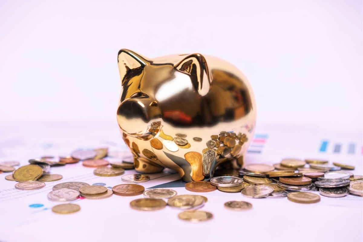 Why You Should Never Publicise Your Children’s Financial Situation A gold piggy bank surrounded by gold and silver coins, symbolising financial matters and the importance of keeping children’s financial status private.