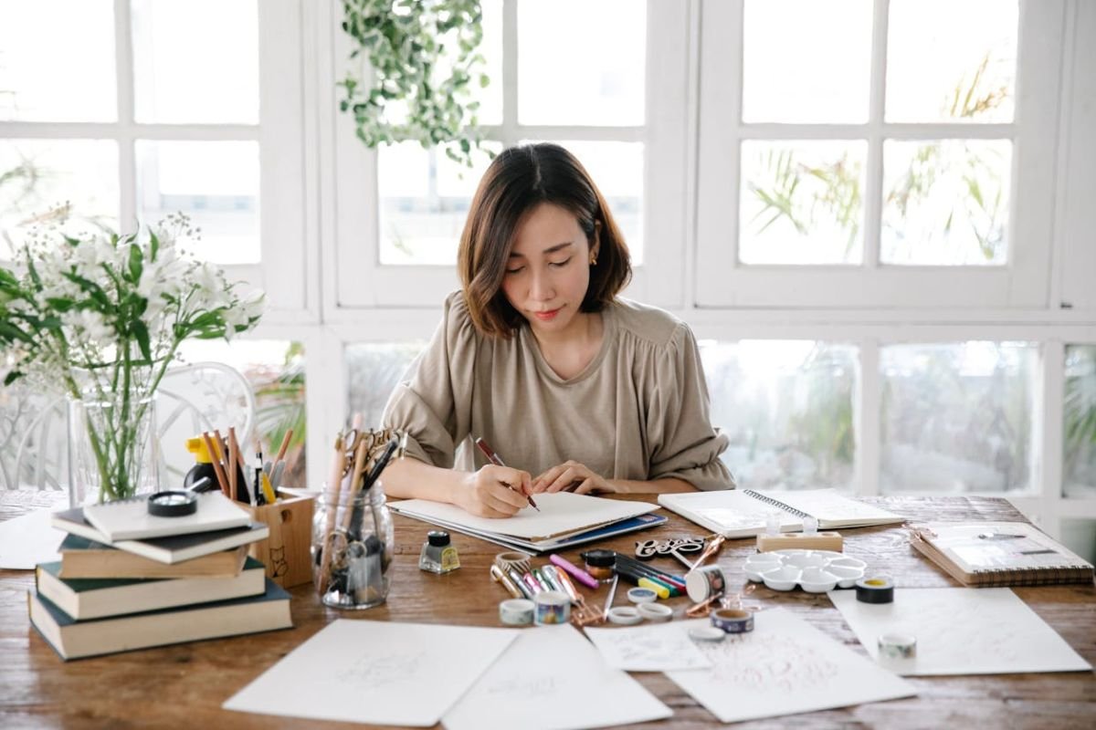 A woman working on an art project alone, symbolising self-reliance and the freedom to focus on personal goals.