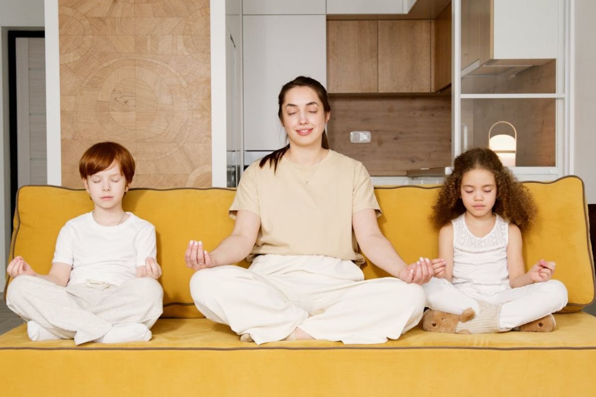 Mindset as Your Greatest Companion: A Woman Meditating with Her Children : A woman meditating peacefully with her children, illustrating the power of mindset in navigating life’s challenges.