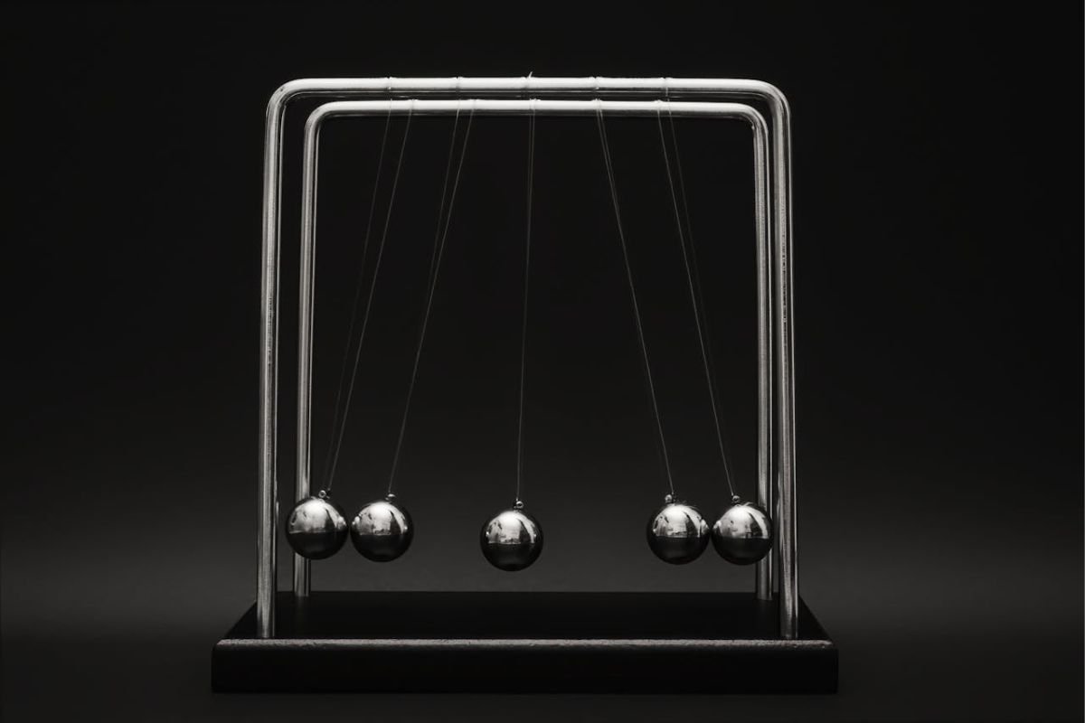 Newton’s Cradle: A Visual Representation of Cause and Effect Close-up of a Newton’s Cradle, symbolising the principle of cause and effect and the ripple effect of actions and reactions.