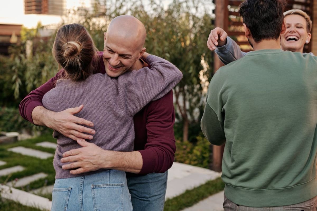 A group of people warmly embracing each other, showing how touch reveals emotions and strengthens social bonds through nonverbal communication.