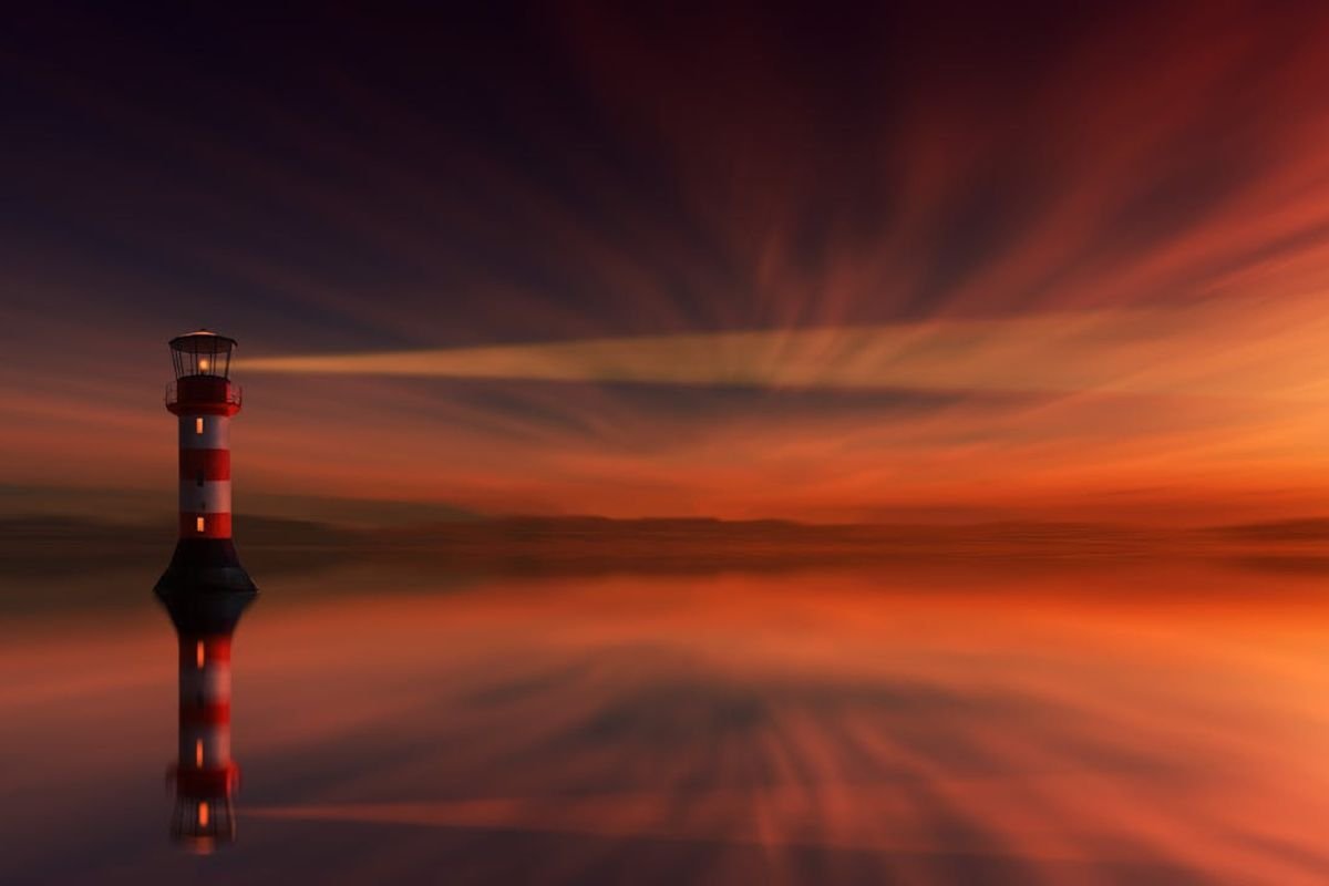 The Lighthouse Mindset: Guiding Your Journey with Strategic Focus A red and white lighthouse shining its light across the horizon, symbolising the 'lighthouse mindset' of focusing on broader, strategic life goals.