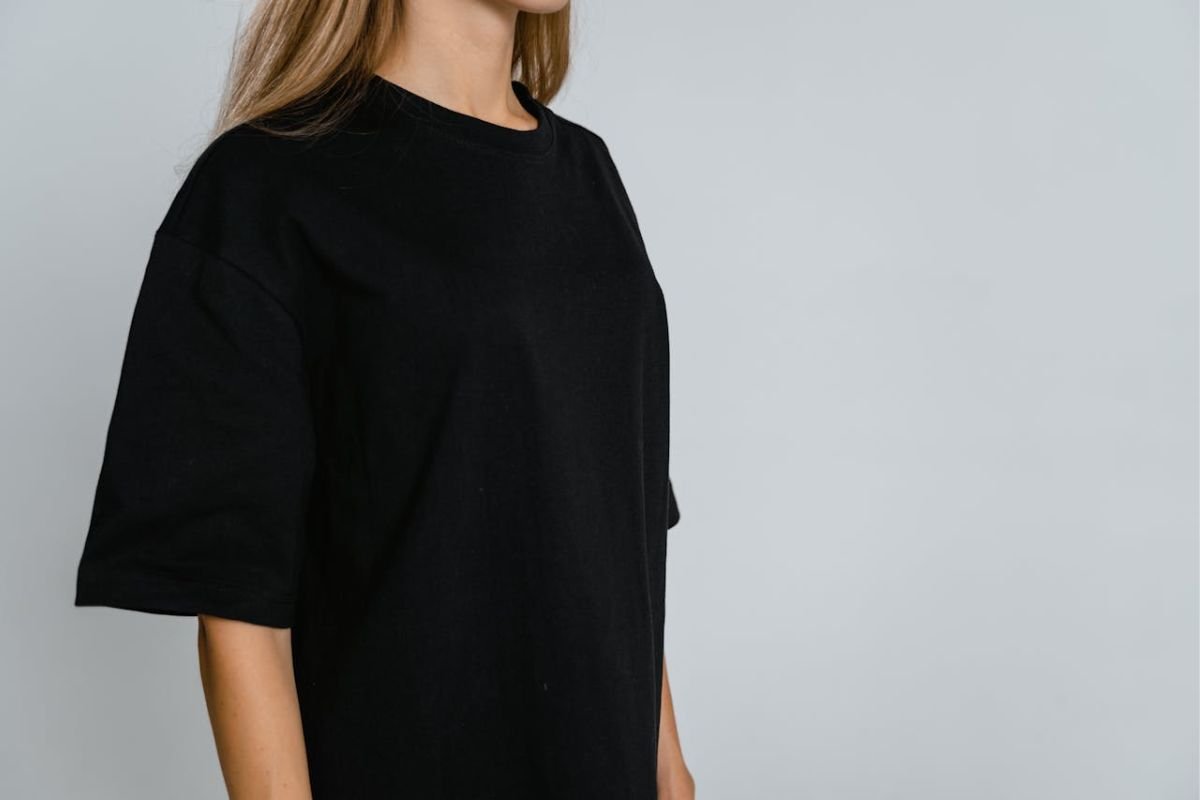 Torso Movements: What They Reveal About Discomfort or Unease A woman in a black crew-neck t-shirt, with her torso prominently displayed, symbolising the vulnerability of vital organs like the heart and lungs.