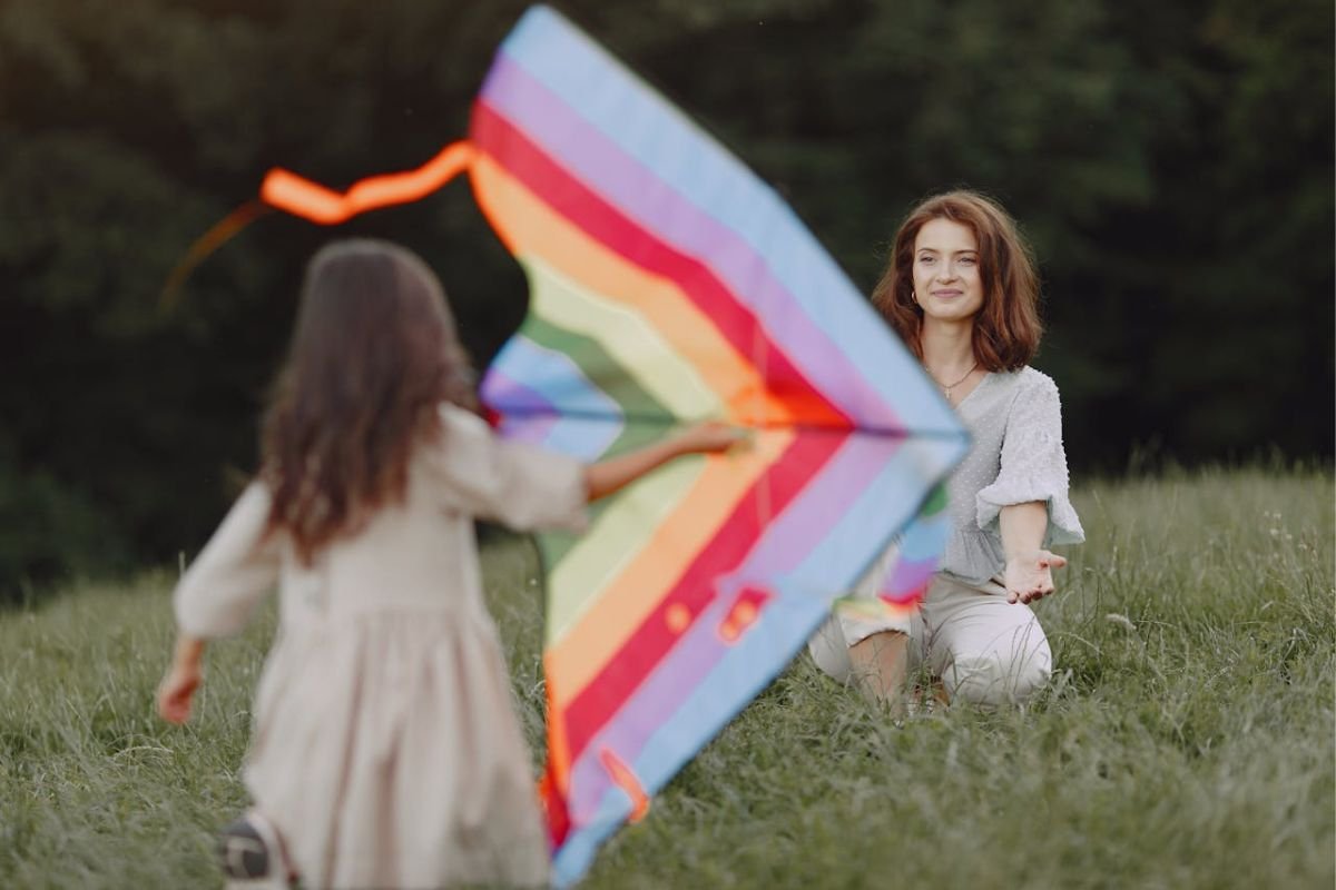 Trust, Let Go, and Watch Them Soar Mother stands back and watches her daughter fly a kite, representing trust, freedom, and gentle parental guidance.