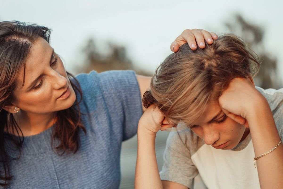 Strengthen Your Connection: How Active Listening Transforms Parent-Teen Conversations A mother and her teenage son sitting together, engaged in a caring conversation, demonstrating active listening and empathy through the questioning method.