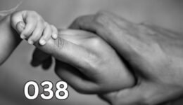 A baby holds its mother’s finger while the father also holds the mother’s hand, symbolising deep questions about life’s meaning and what truly matters.