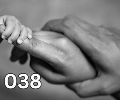 A baby holds its mother’s finger while the father also holds the mother’s hand, symbolising deep questions about life’s meaning and what truly matters.