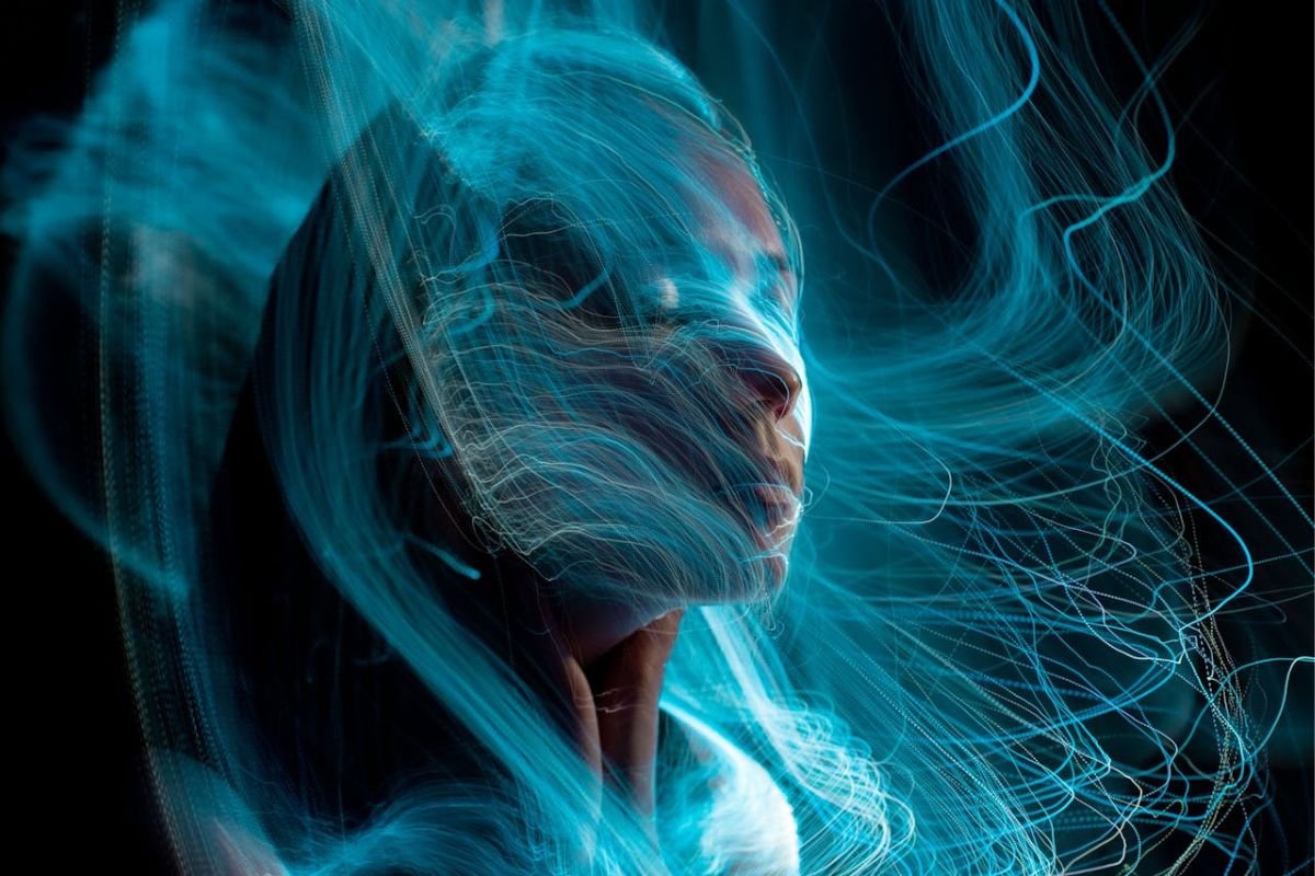 The Energy of Emotion: A Visual Representation of Empaths A woman surrounded by glowing energy waves, symbolising the emotional depth and energetic sensitivity of an empath.