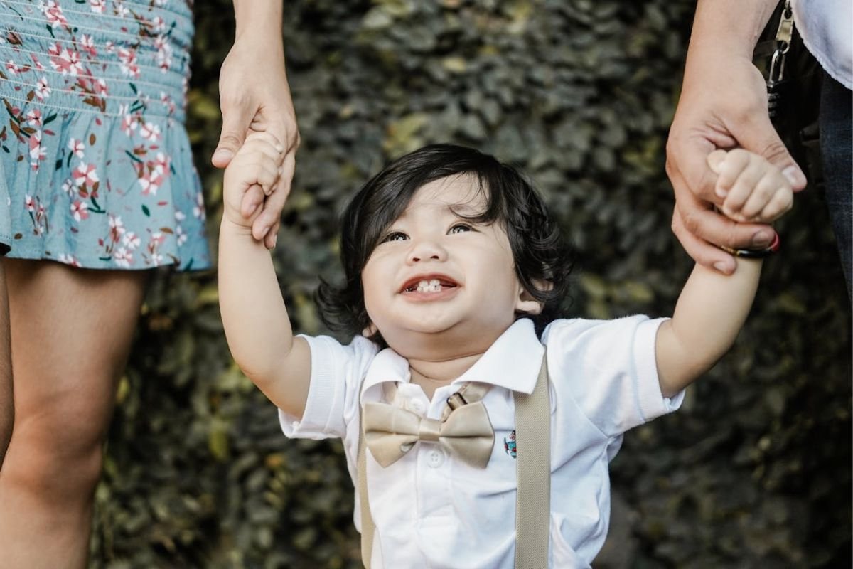 Full Circle - Returning to Where It All Began A joyful child holds hands with both parents, looking up with love, symbolising the story’s ending, returning to innocence at seventy-six, reunited once more.