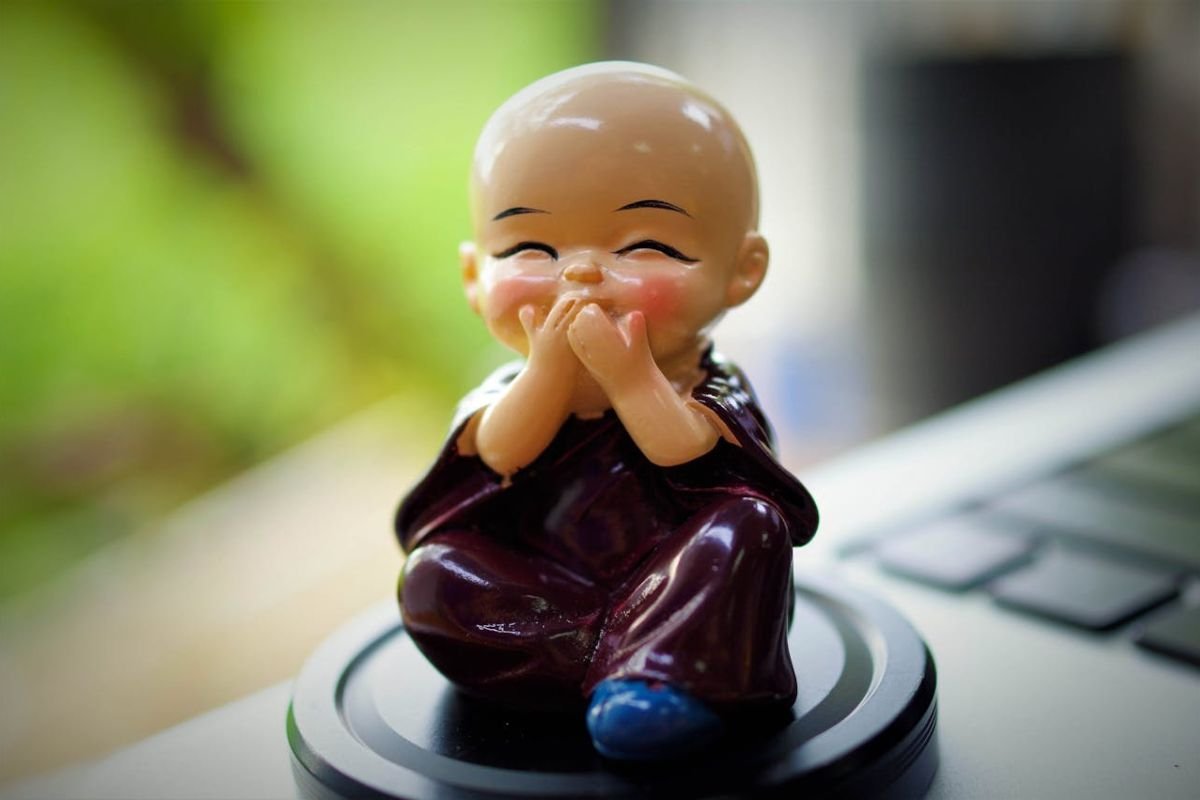 The Secret to Happiness - A Lesson from a Young Monk A figurine of a young happy monk, symbolising the short story “The Secret to Happiness: Living in the Present” about the young and old monk.