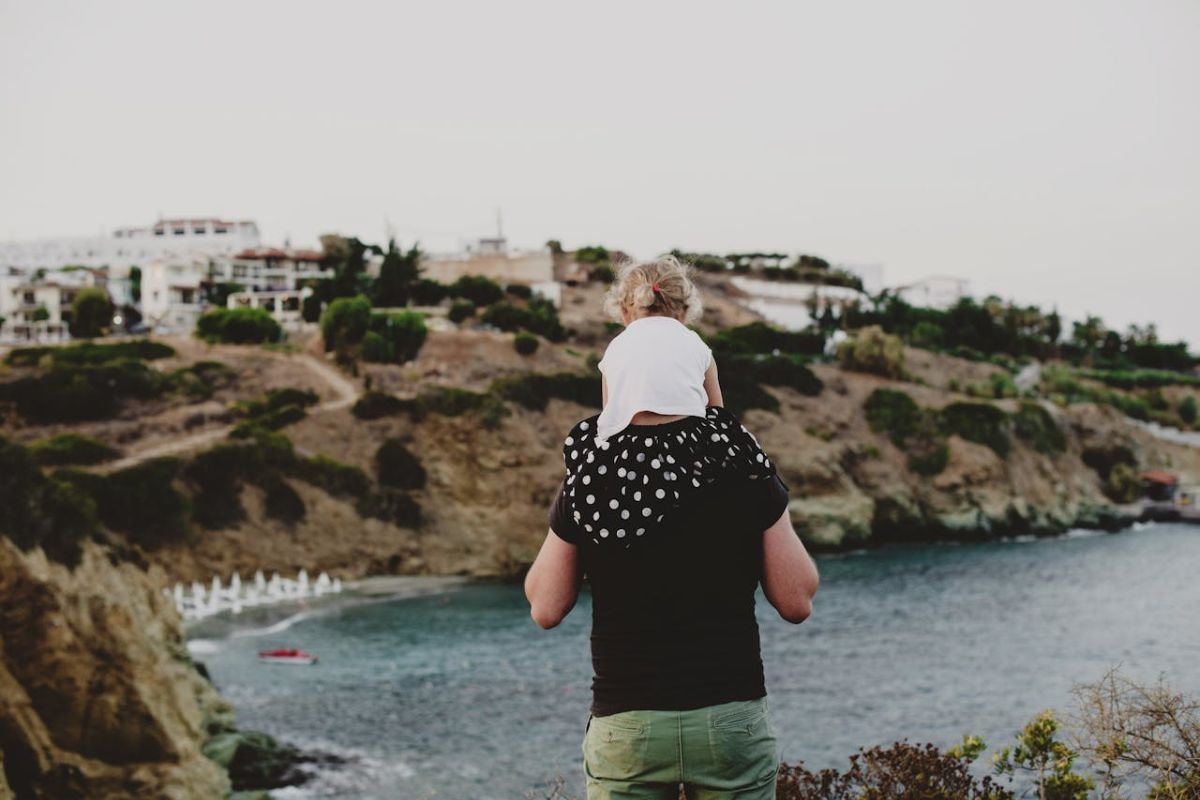 Carrying Purpose with Strength: A Visual Metaphor for a Strong Mindset A child sits on her father’s shoulders, representing purpose, strength, and the ability to carry what truly matters in life.