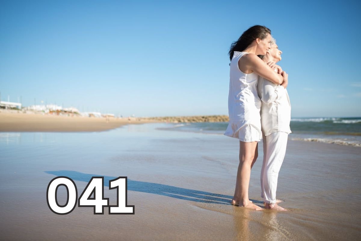 Elderly mother and adult daughter hugging affectionately on the beach, symbolising a deep, loving bond across generations.