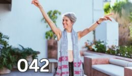Joyful woman with arms raised, symbolising freedom and the happiness of living a simpler life.