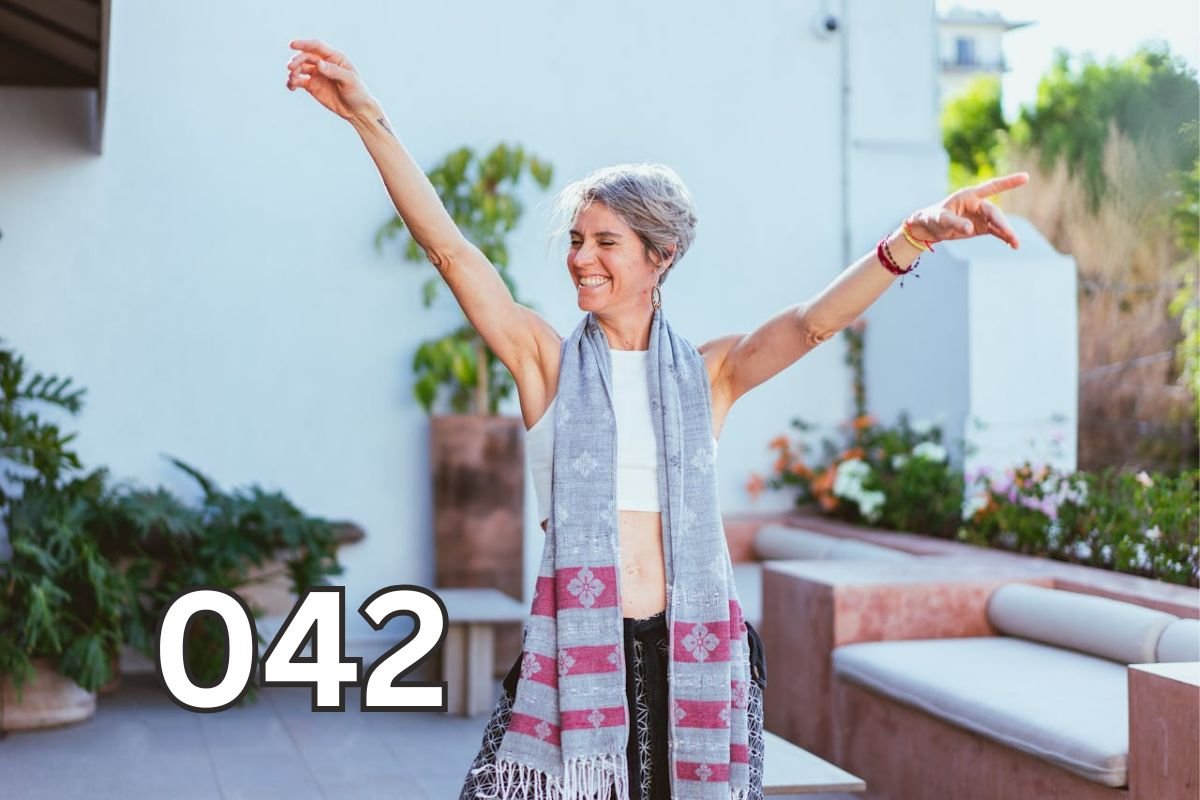 Joyful woman with arms raised, symbolising freedom and the happiness of living a simpler life.