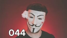 Person wearing a Guy Fawkes mask with a flower, symbolising hidden traits of antisocial personality disorder.