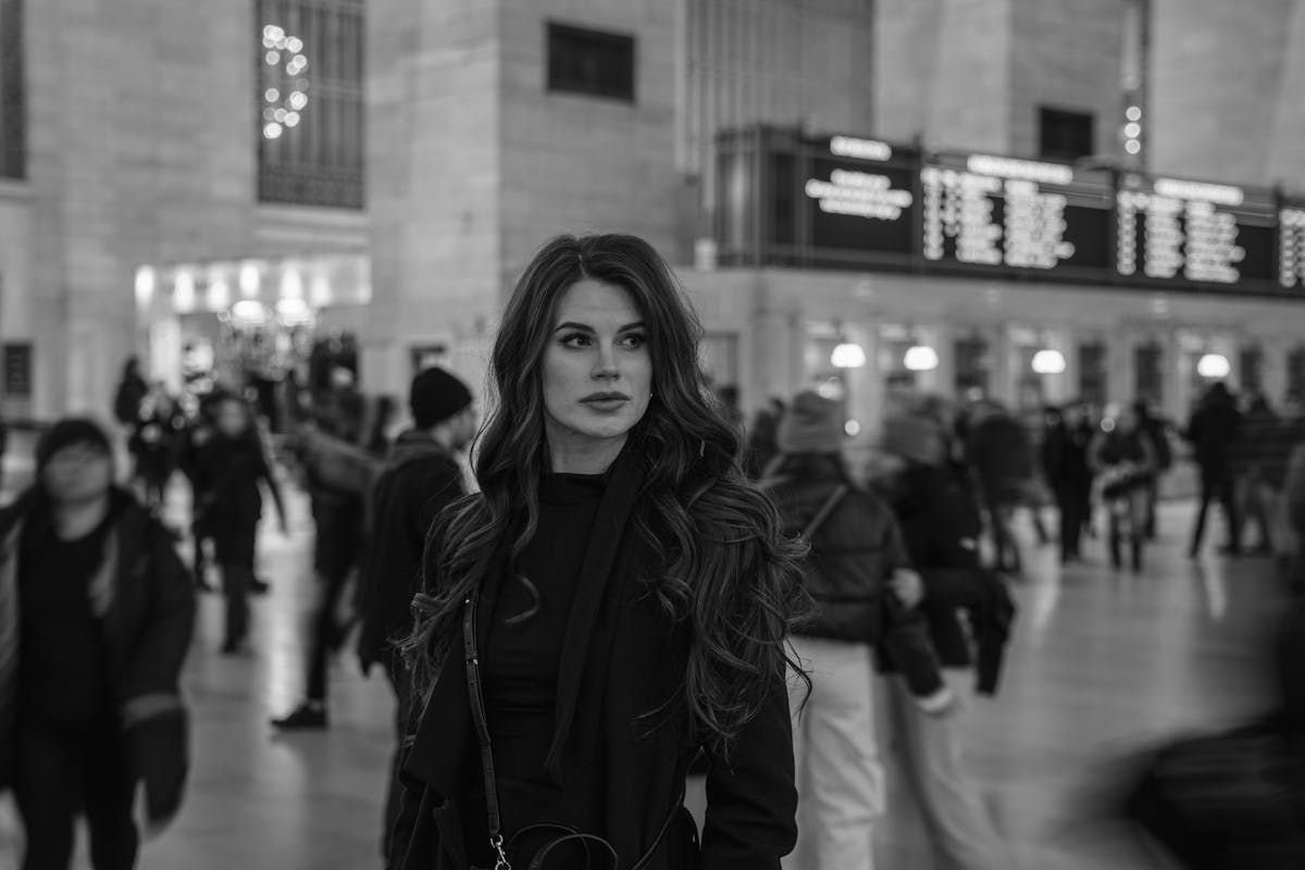 What If You’ve Already Met Someone With Antisocial Personality Disorder? Woman standing still in a busy train station, symbolising how people with antisocial personality disorder blend in unnoticed.
