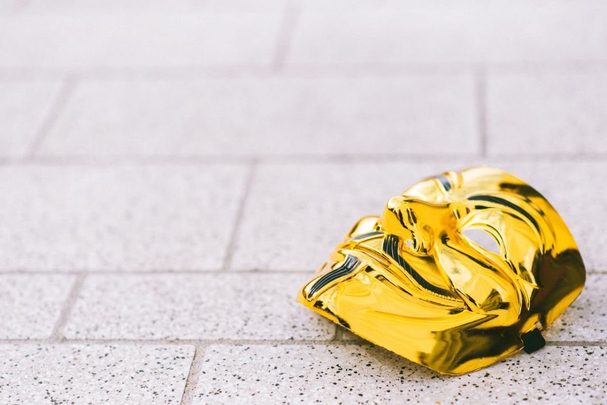 When the Mask Falls: Uncovering Antisocial Traits Beneath the Surface Gold mask lying on the ground, symbolising the unraveling of a hidden antisocial identity.