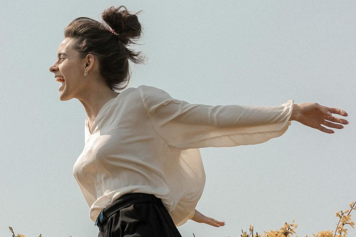Woman Releasing Emotion in a Blooming Field Woman with arms open shouting joyfully in a flower field, expressing emotional release and freedom through openness.