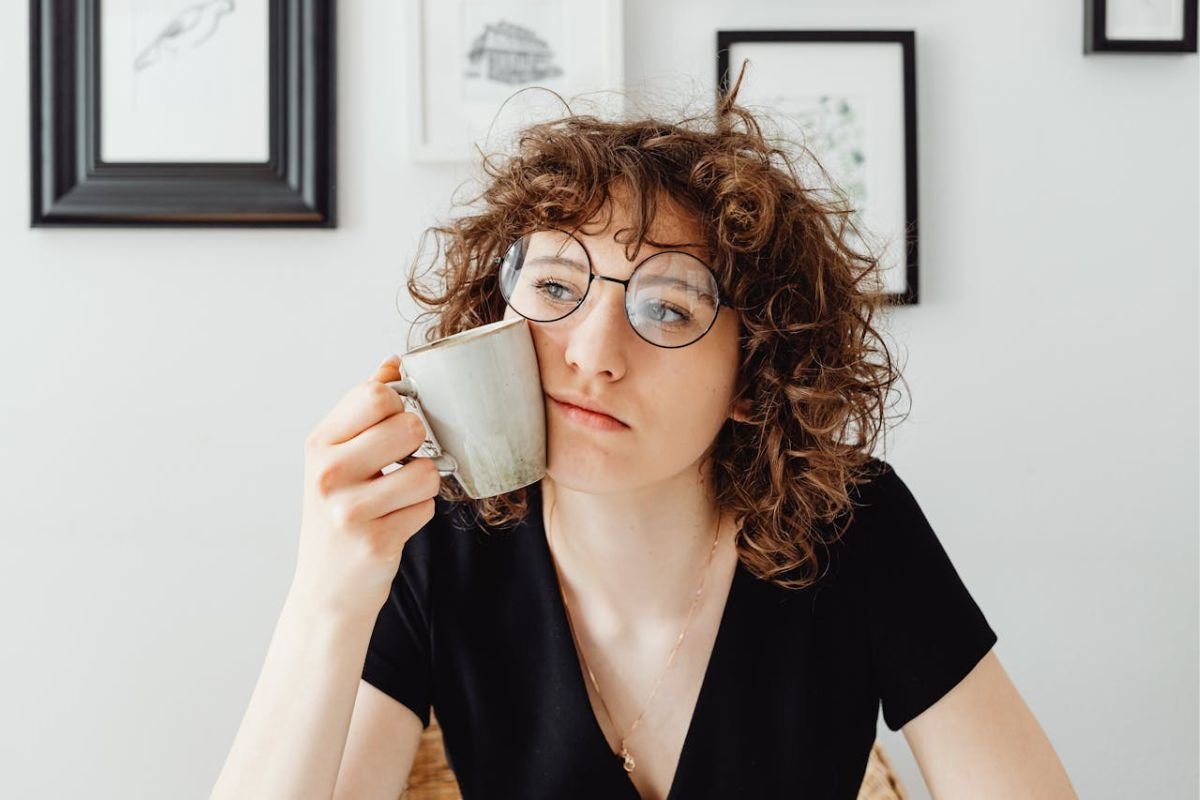 Worried You Might Have Antisocial Traits? Here’s What You Should Know Concerned woman holding a coffee mug, symbolising self-reflection and worry about possibly having antisocial traits.