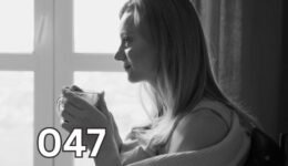 Thoughtful woman holding coffee mug, gazing into distance in grayscale photo