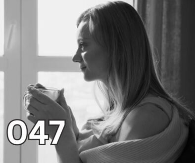 Thoughtful woman holding coffee mug, gazing into distance in grayscale photo