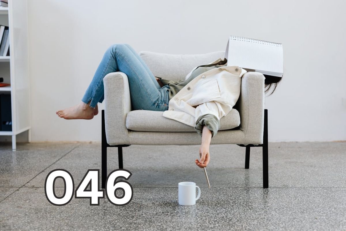 Exhausted woman lying on a couch with a notebook over her face, capturing silent burnout and emotional fatigue