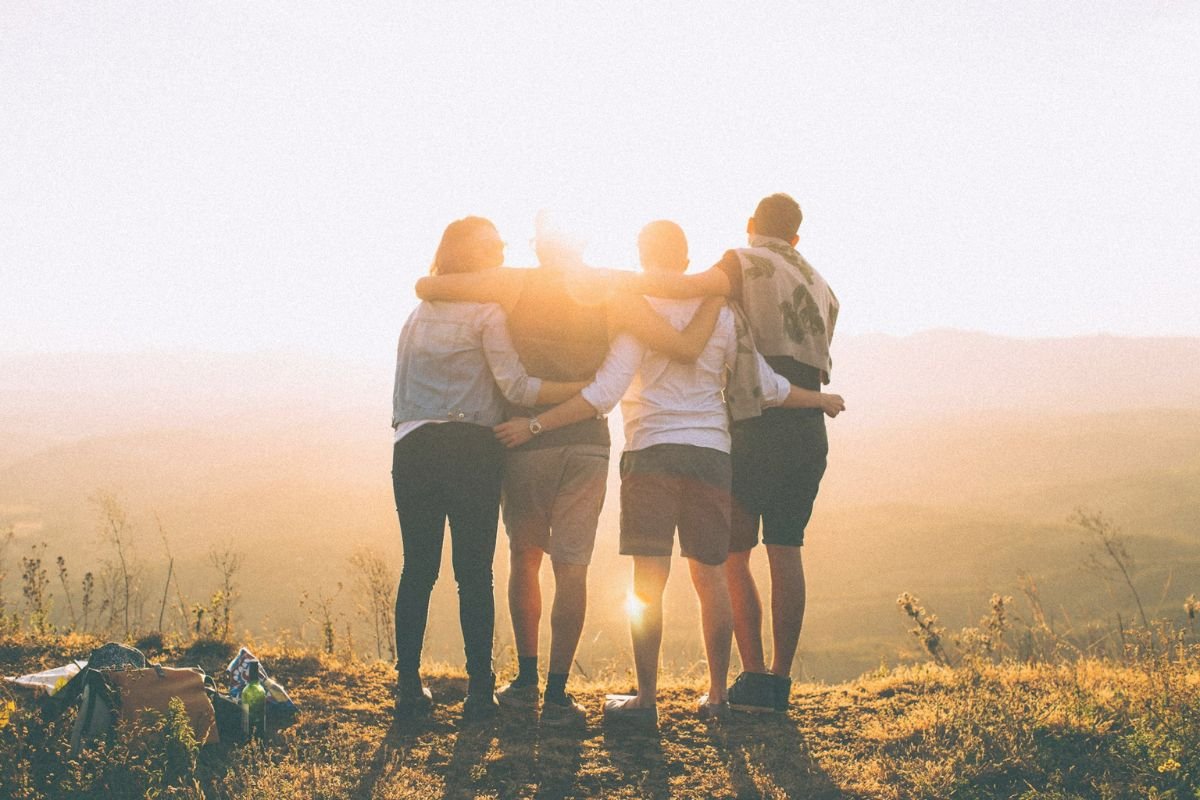 The Psychology of Friendship – A Symbol of Instant Connection and Trust Group of friends with arms around each other watching the sunset, symbolising deep friendship and strong emotional bonds.