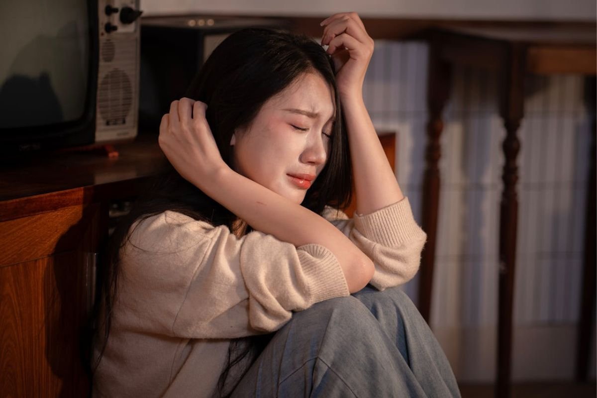 When You’re in Pain, Silence Can Be a Safe Space Upset woman sitting on the floor crying, symbolising emotional pain and the weight of silent suffering