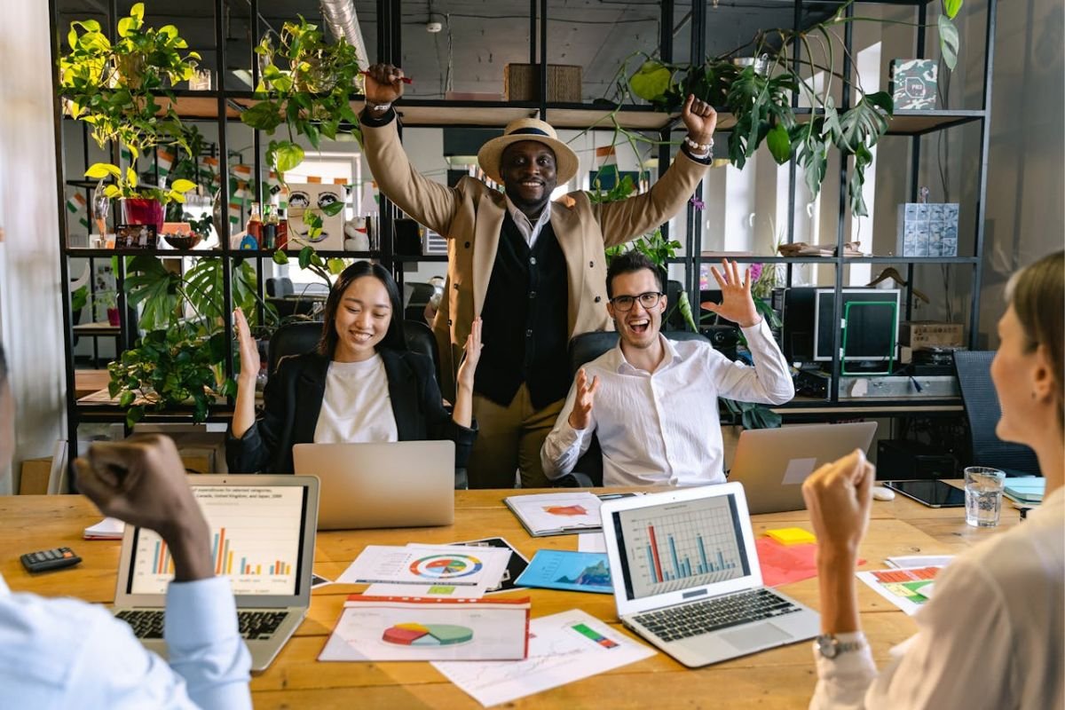 Celebrate Generosity - Good Energy Spreads, Even at Work Team of coworkers celebrating at desk, symbolizing how generosity and shared joy bring success in the workplace