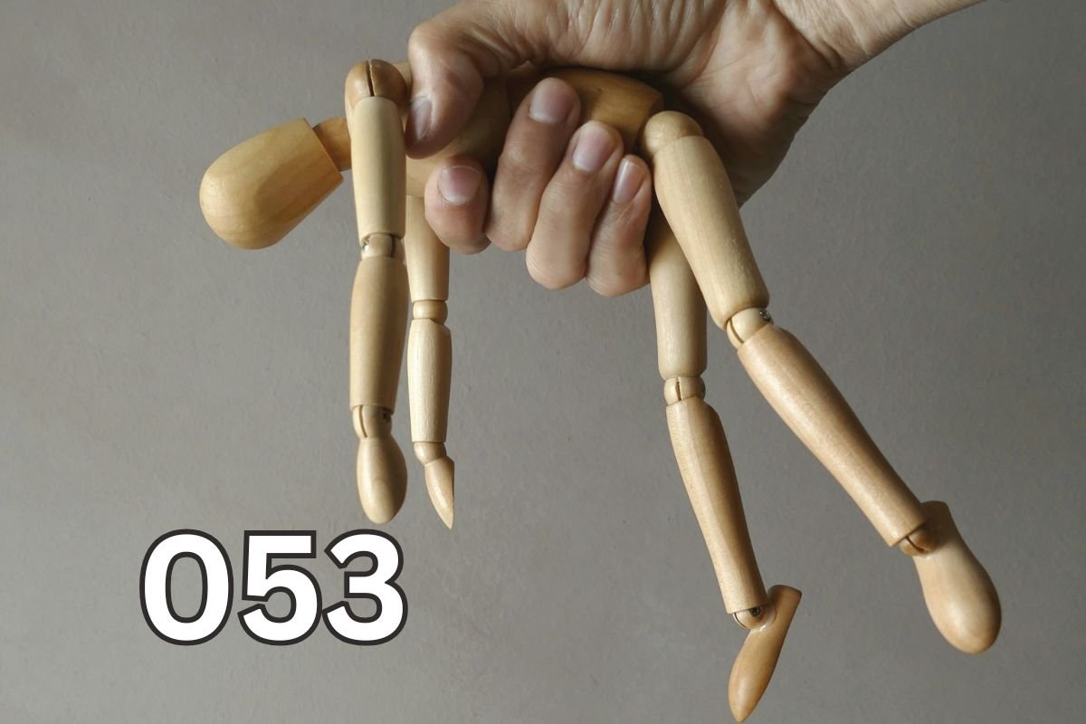 Are You Being Emotionally Manipulated? Visual Symbol of Control Hand holding a wooden mannequin like a puppet, symbolising emotional manipulation and control in relationships.