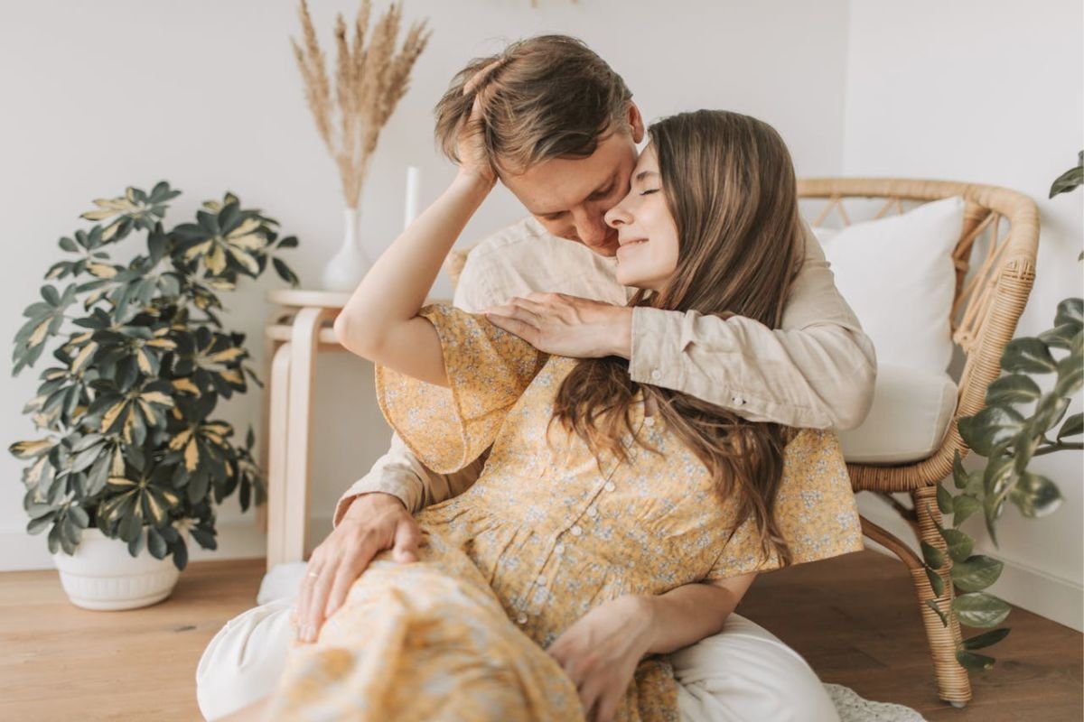 Man hugging woman from behind, representing emotional support, safety, and the quiet strength of a loving husband